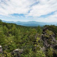 鬼押出しの浅間園から眺める樹海と山並み、溶岩岩場の景観の写真