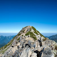 山頂から見た青空と険しい岩峰の絶景風景の写真