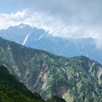迫りくる雲と三大キレット連峰の登山風景、険しい山々の絶景の写真