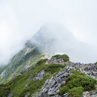 視界不良の雲の中に進む八峰キレットの登山道の写真