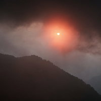 八峰キレット縦走での不気味な赤い夕陽と山のシルエットの写真