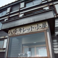 八峰キレット小屋の看板と木造山小屋の外観の写真