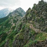 八峰キレットの荒々しい岩稜沿いの登山道と北アルプスの縦走ルートの写真