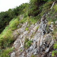 八峰キレット縦走の足場の悪い斜面の鎖場と登山道の写真