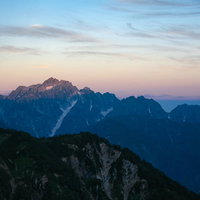 朝焼けに染まる八峰キレット連峰の壮大なシルエット風景の写真