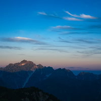 朝日を浴びる山々と朝焼けのシルエット 夜明けの絶景の写真