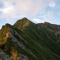 朝日を浴びる八峰キレットの尾根と岩稜を行く登山者の写真
