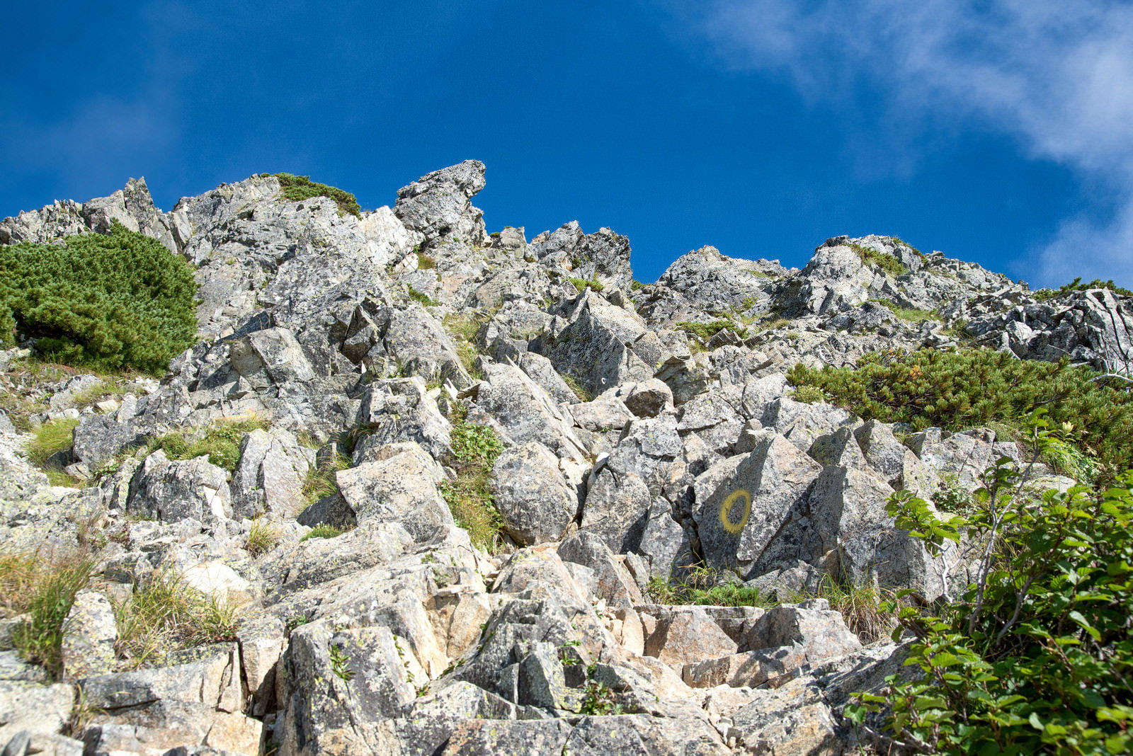 青空に向かって続くゴツゴツとした白い岩稜の山岳風景
