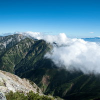 八峰キレット縦走で稜線に覆いかかる雲と山々の景観の写真