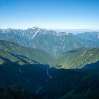 八峰キレット縦走路の尾根に差す光と影、青空と山脈の絶景の写真