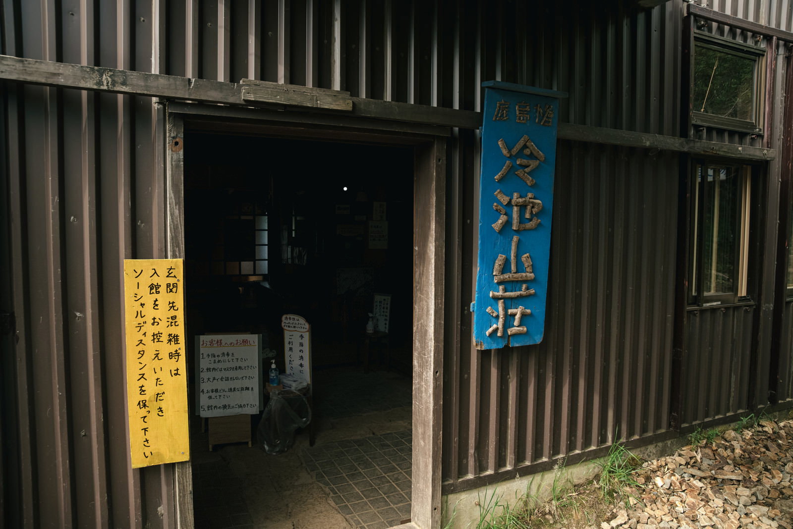 冷池山荘の表札が掛かった木造建物の玄関
