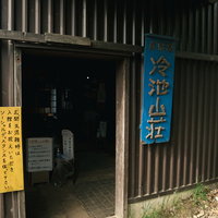 冷池山荘の表札と木造玄関、北アルプス登山道沿いの山小屋の写真