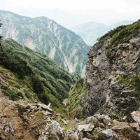 八峰キレット縦走時に登山道から見た山々と霞む空の写真