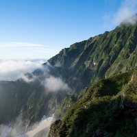 雲海を望む山の稜線で登山者が歩む高山の絶景の写真