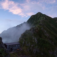 夕焼けに染まる稜線と山荘、八峰キレット、キレット縦走の登山風景の写真