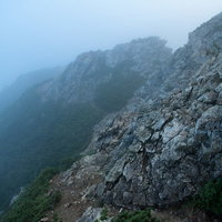 朝霧が立ち込める八峰キレットの岩稜沿い登山道の写真