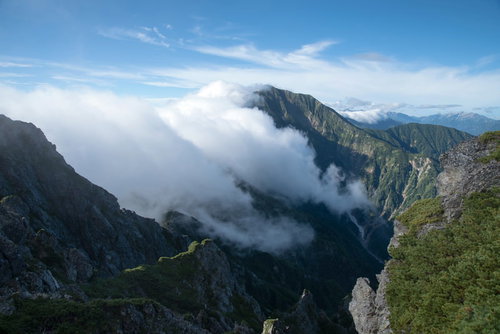 長く伸びる稜線に覆いかぶさる雲と連峰、八峰キレット