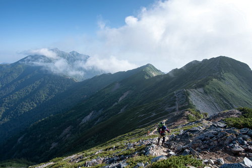 どこまでも続く稜線と登山道を歩む登山者たちの姿