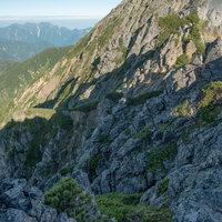 登山道から見下ろした八峰キレットの岩稜と影の写真