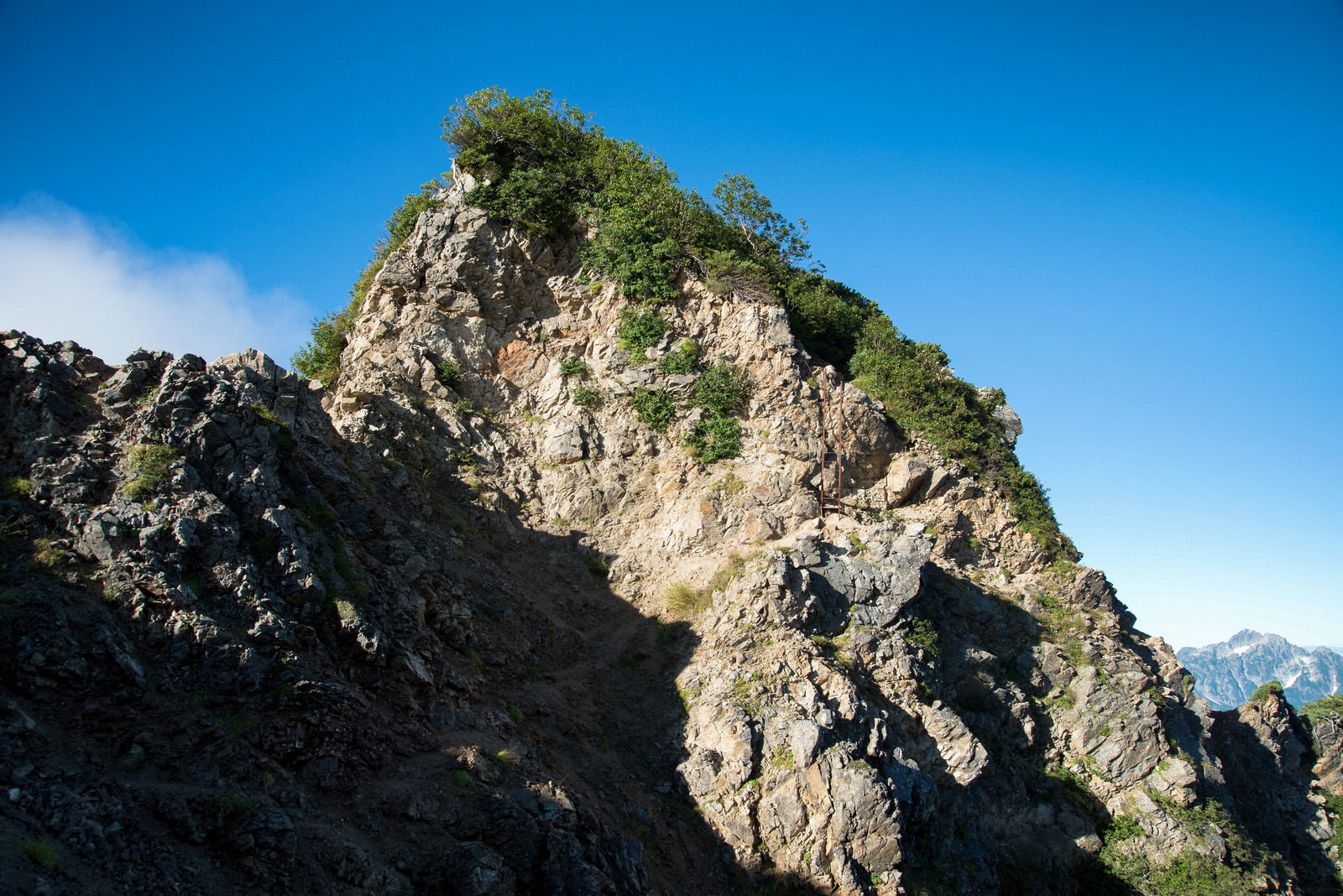 青空をバックに切り立った岩石の登山道が続く八峰キレットの風景