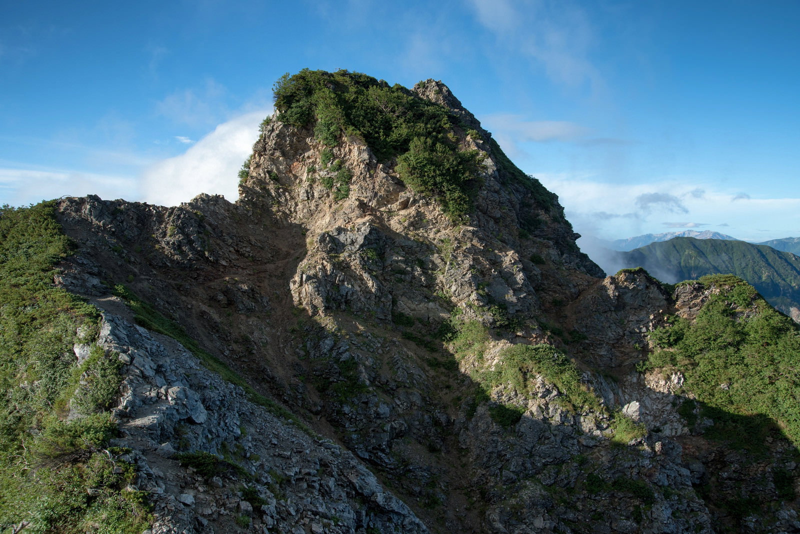青空の下、険しい岩稜が連なる八峰キレットの登山道
