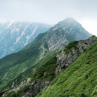 雲で隠れた岩尾根と切り立つ山々の八峰キレット縦走路の写真
