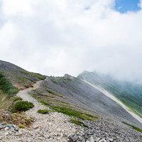 雲の中に消えゆく登山者と八峰キレットの稜線の写真