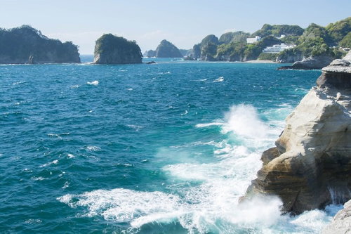 伊豆の断崖に打ち寄せる波としぶき、荒波が岩場に激突する海景