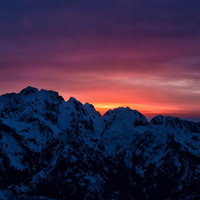 剱岳に沈む夕日と残雪の稜線の写真