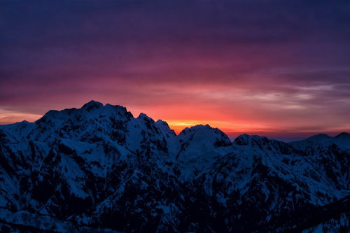 剱岳に沈む夕日と残雪の稜線