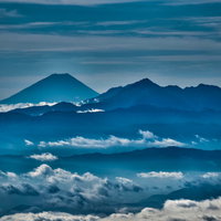 北アルプスの山峰が雲海に浮かぶシルエットの写真