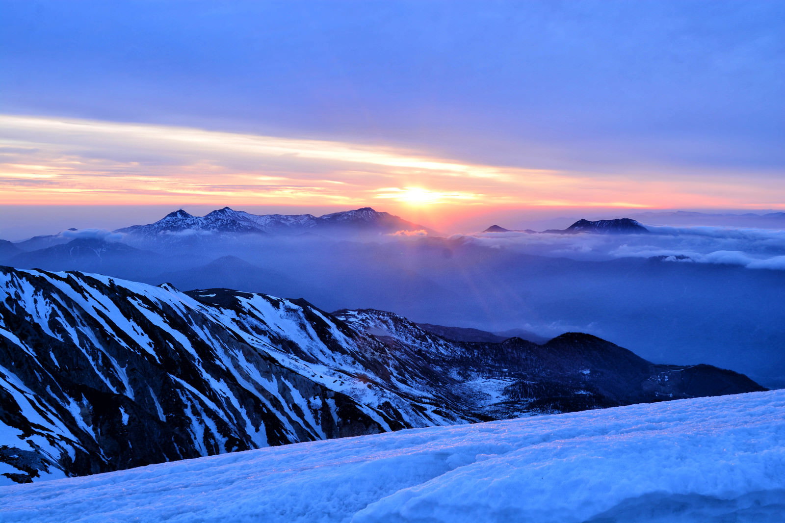 雪山から望む夜明けの日の出と朝焼け
