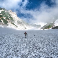 白馬の大雪渓を歩む登山者と雪山の風景の写真