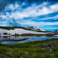 水鏡の白馬大池に映る雪の山荘（北アルプス登山）の写真