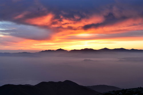 夕焼けに染まる南アルプスのシルエットと雲海