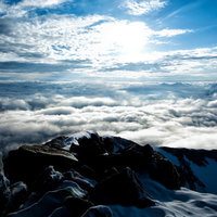 山頂から眼下に広がる雲海と雪山の絶景の写真