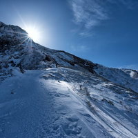 厳冬の雪山を歩く人の足跡の写真