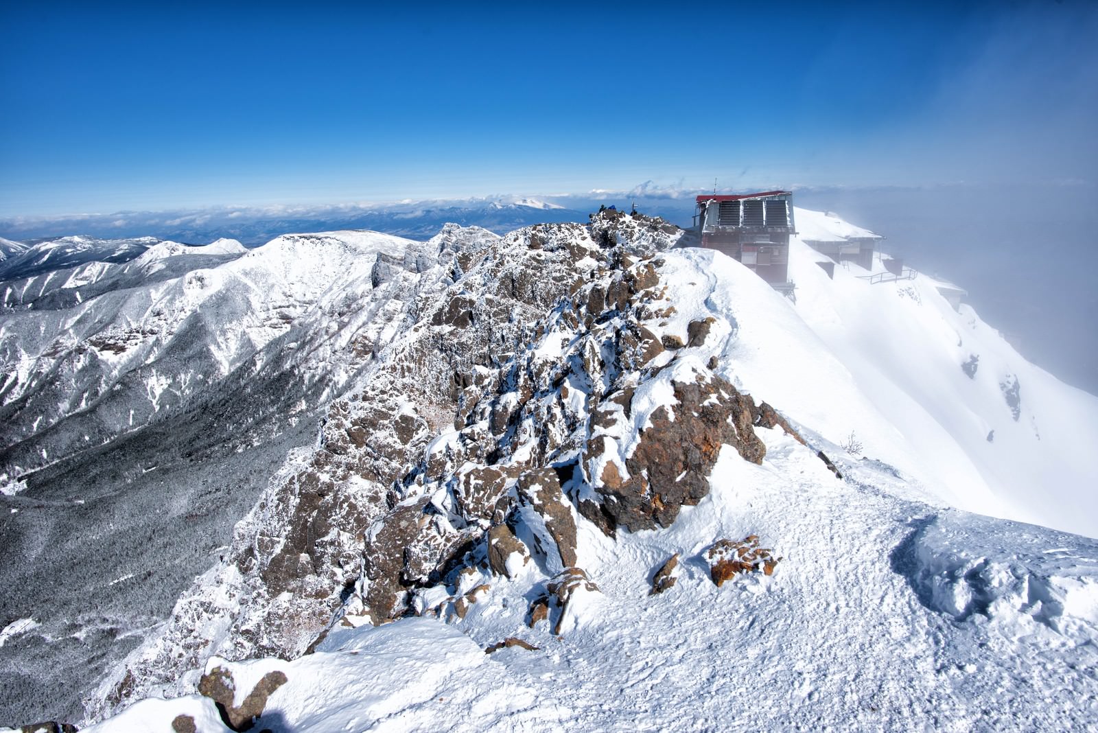 雪に覆われた赤岳の山頂と青空が広がる冬の山岳風景