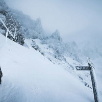 トレースの無い赤岳山頂直下の積雪岩場と指導標の写真