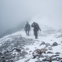 ホワイトアウト発生時に雪山を下山する登山者の写真