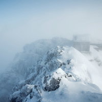 雲に飲まれた赤岳山頂、八ヶ岳連峰の積雪風景の写真