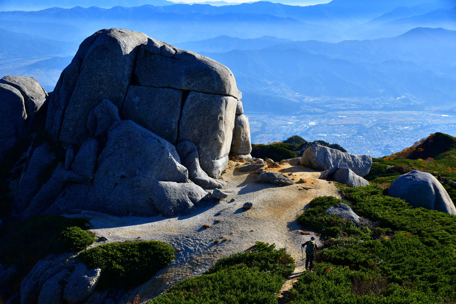 中央アルプスの巨大な駒石の前で休憩する登山者の風景