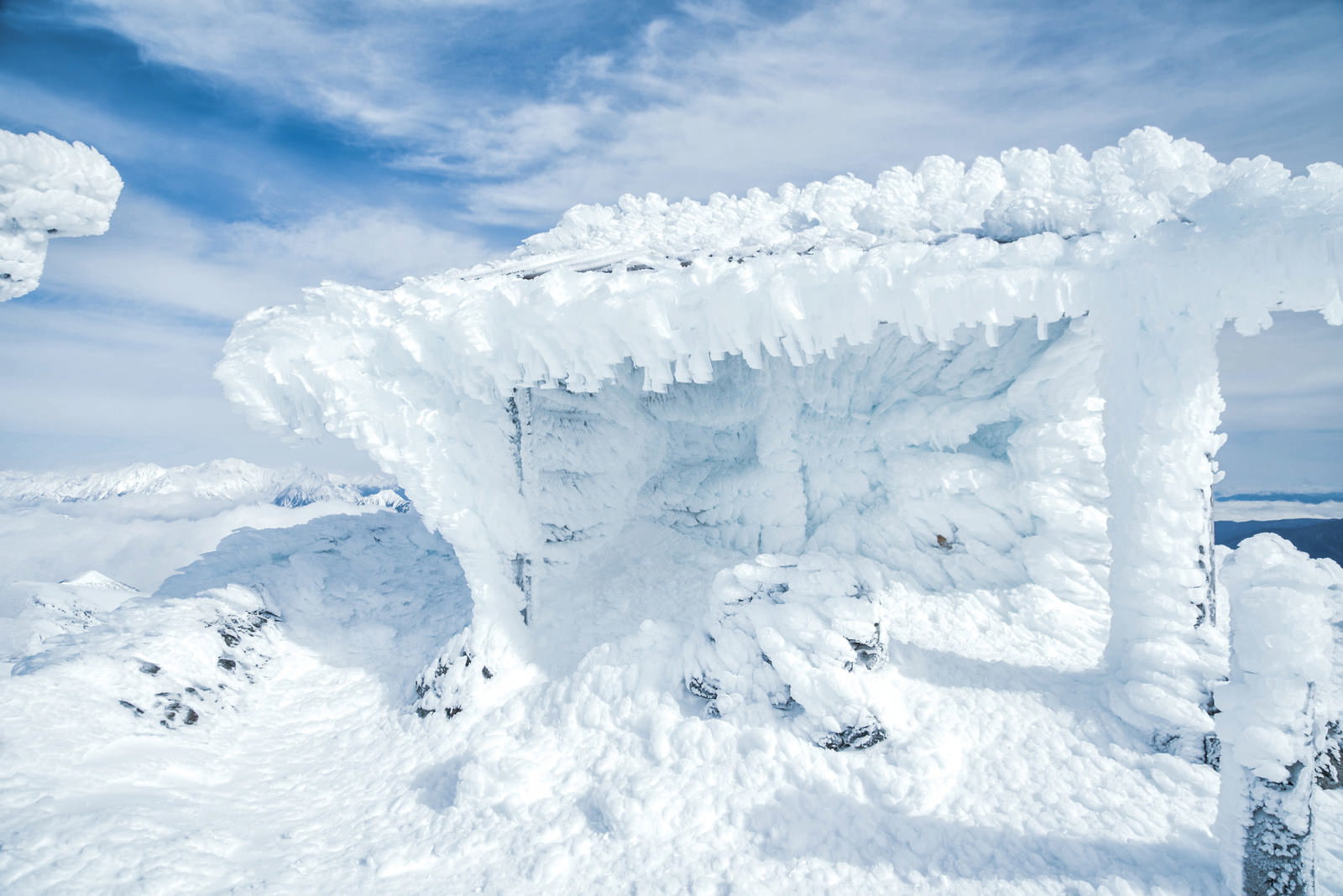 雪に覆われた乗鞍岳剣ヶ峰の山頂に建つ御社と霧氷