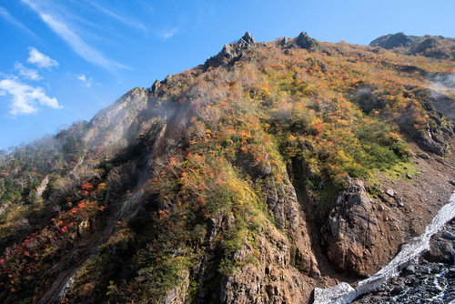 紅葉に染まる秋の針ノ木谷の山肌と岩場の登山風景