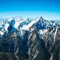 初冬の槍ヶ岳、雪化粧した鋭い山頂が青空に映える北アルプスの写真