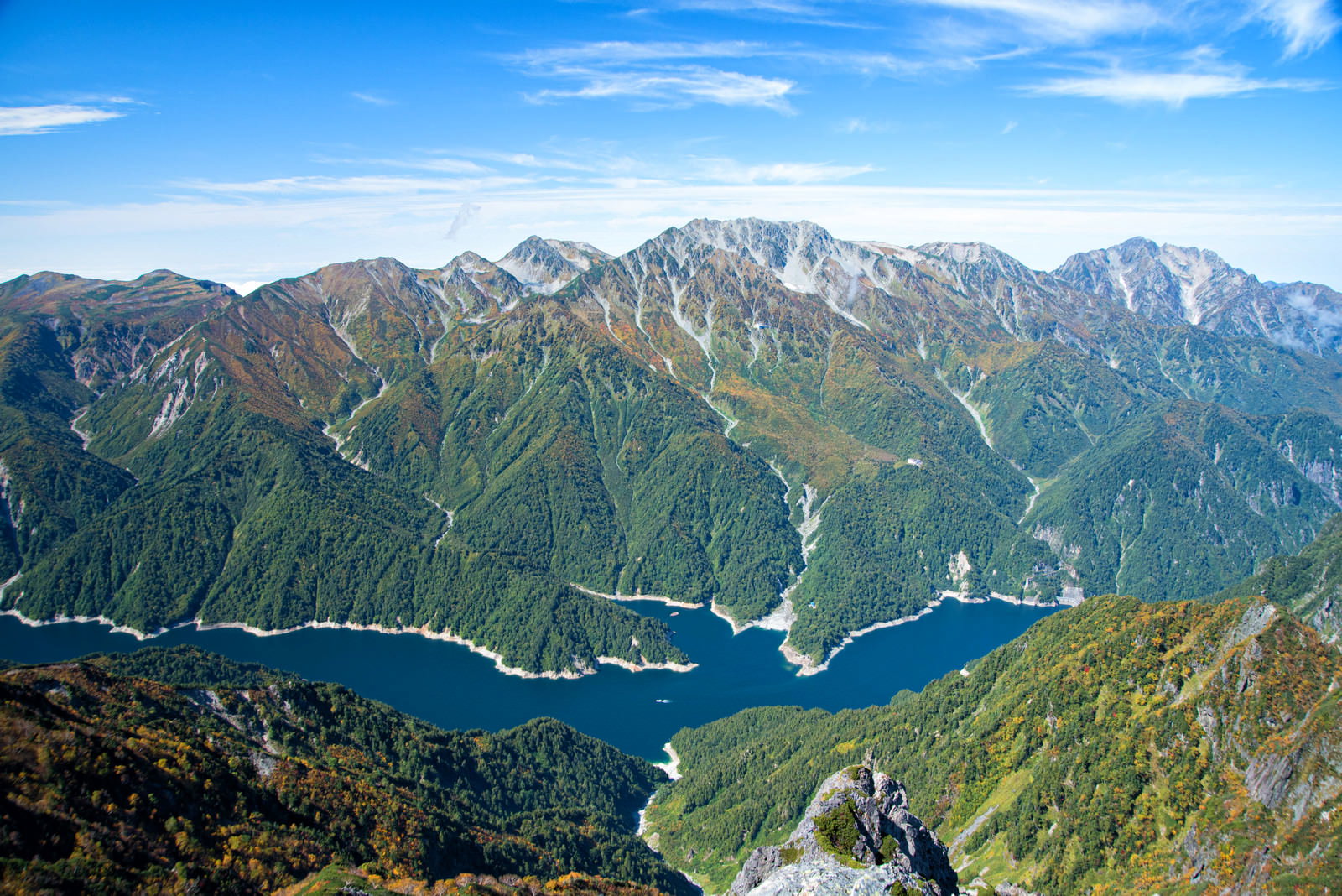 針ノ木岳山頂から見た立山連峰の山並みと青空に浮かぶ白い雲