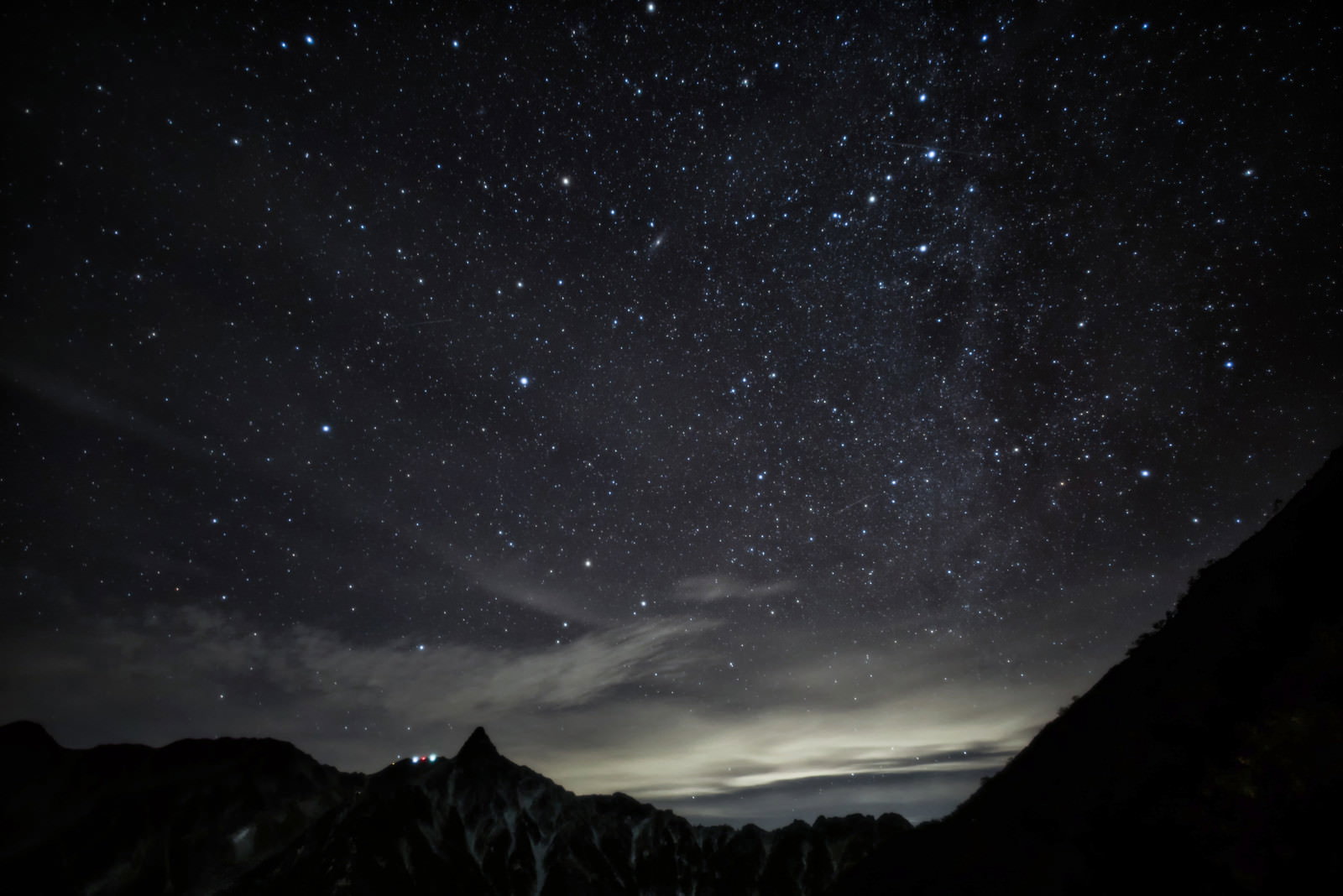漆黒の夜空に輝く星々と槍ヶ岳のシルエットが美しい山岳風景
