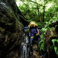 小さな滝を直登するヘルメット着用のクライマーの写真