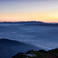 眼下に広がる伊那市の街並みと朝焼けに染まる八ヶ岳の写真