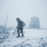 雪山の暴風に晒される登山者の写真